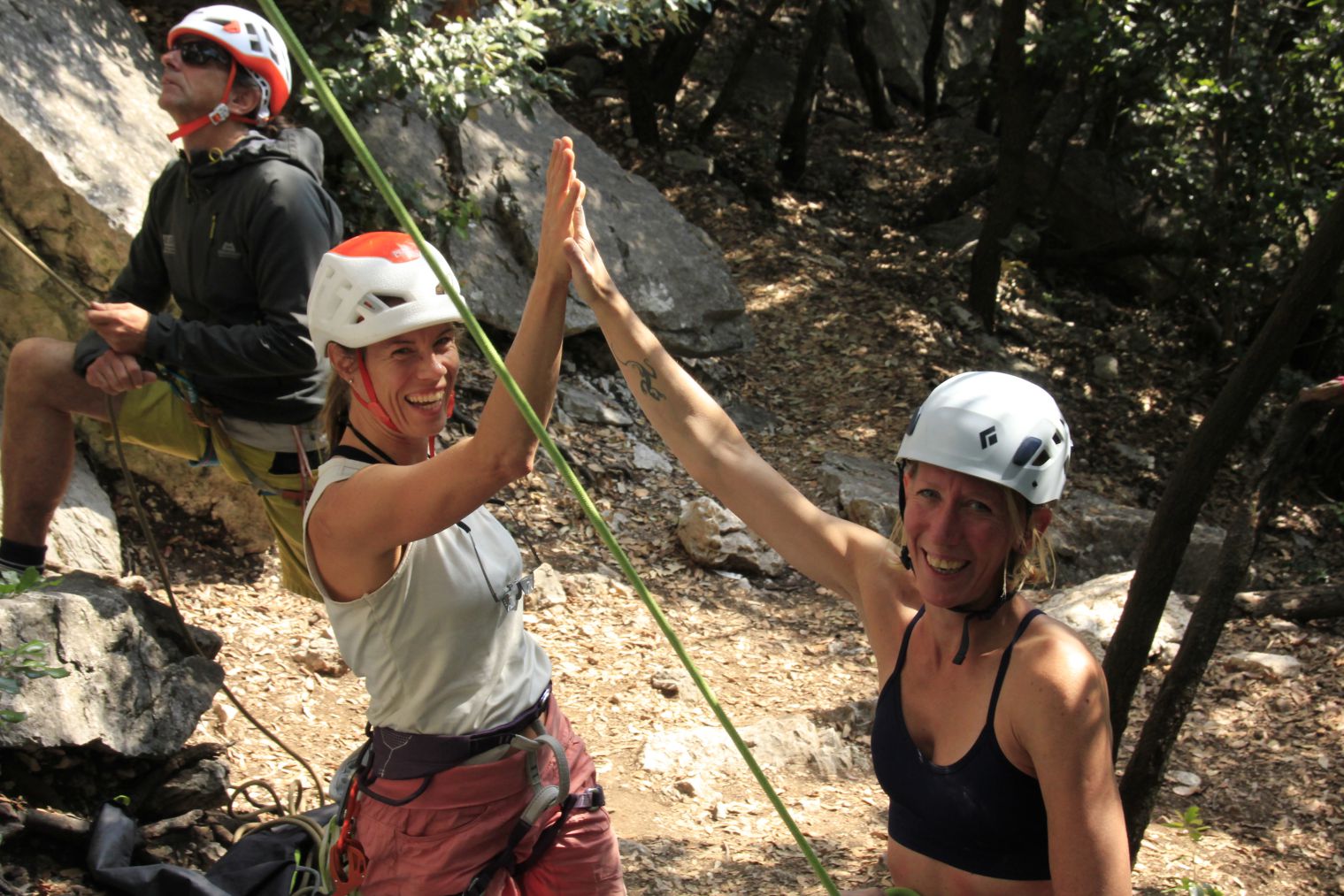 Frauen beim High five beim Klettern in Arco