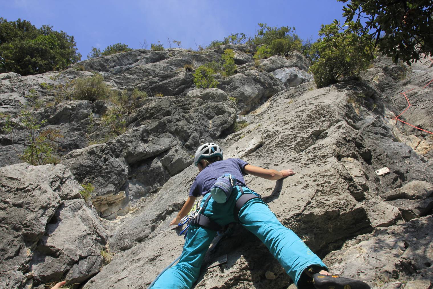 Frau beim Klettern am Fels in Arco