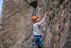 Frau beim Klettern im Gneis